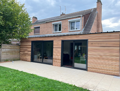 Photo d'une extension de maison en ossature bois, avec un bardage en bois et deux baies vitrées