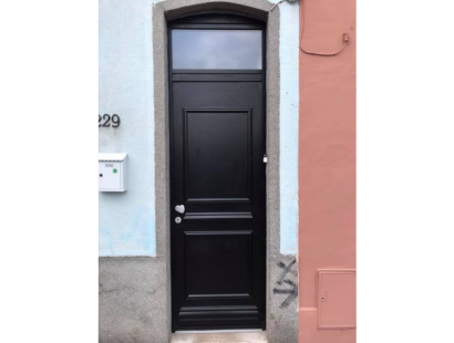 Photographie d'une porte d'entrée en bois massif noire, posée par creanov