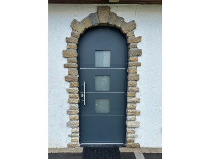 Photo d'une porte d'entrée sur mesure avec pourtour en pierre naturelle