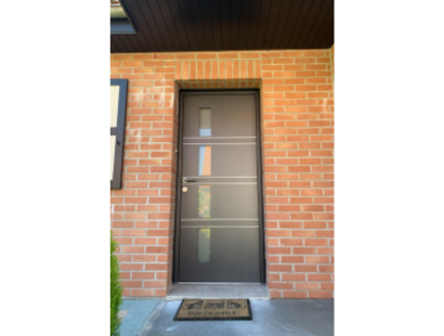 Photo d'une porte d'entrée en bois grise sous un porche